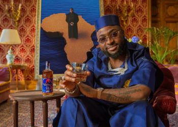 Davido raises a glass beside the Martell VS Afrobeats limited-edition bottle designed with Prince Gyasi