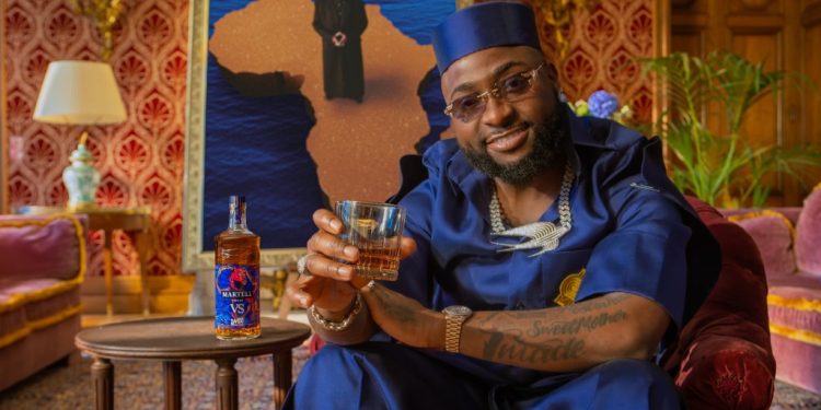 Davido raises a glass beside the Martell VS Afrobeats limited-edition bottle designed with Prince Gyasi