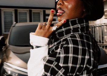 Gyakie in a black-and-white checked shirt and sunglasses during her media run