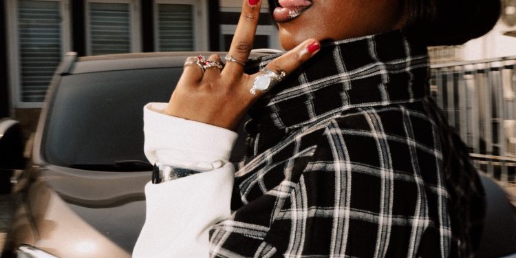 Gyakie in a black-and-white checked shirt and sunglasses during her media run