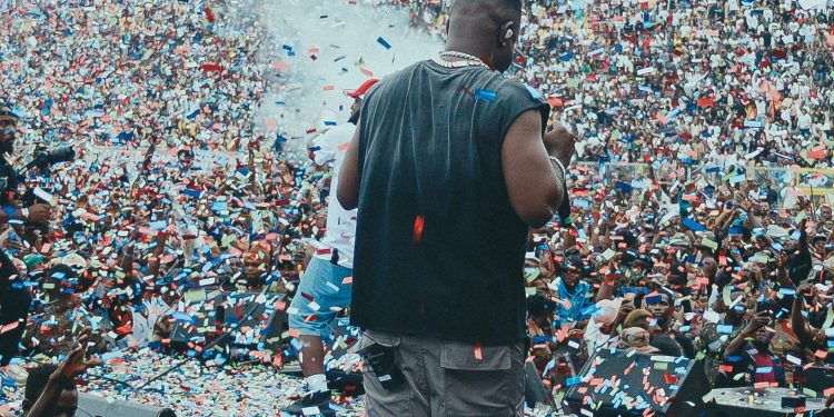 Sarkodie on stage facing a packed Baba Yara Sports Stadium crowd under falling confetti at Rapperholic Kumasi 26
